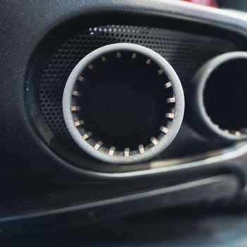 detail rear view of black sport car pair of exhaust pipes with dark mesh grill